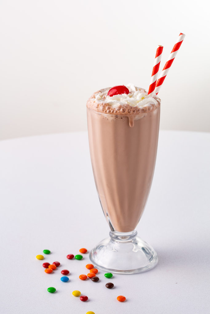 Chocolate milkshake in a glass with cherry topping